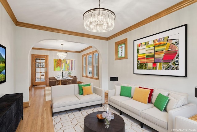 living area with crown molding, arched walkways, wood finished floors, and a notable chandelier