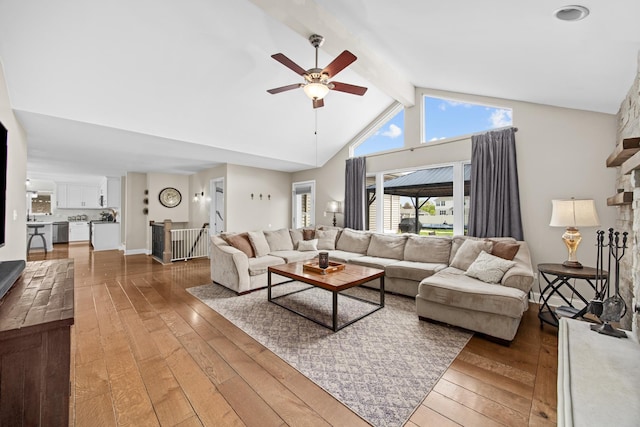 living area with wood-type flooring, ceiling fan, high vaulted ceiling, and beamed ceiling