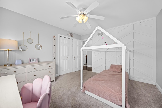bedroom with light colored carpet, baseboards, ceiling fan, and a closet
