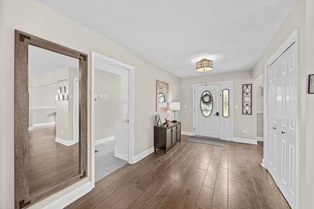 foyer entrance with baseboards and wood finished floors