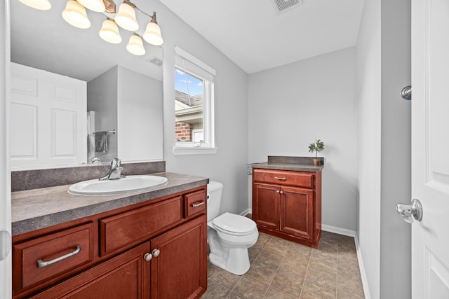 bathroom featuring a notable chandelier, vanity, toilet, baseboards, and visible vents