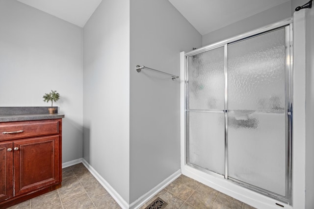 full bathroom with baseboards, visible vents, and a shower stall