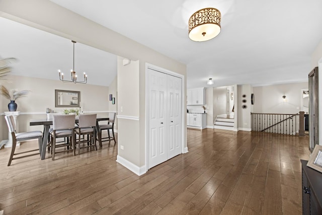 interior space with baseboards, a chandelier, and wood finished floors