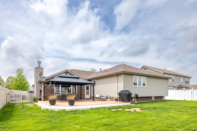 back of property featuring a gazebo, a fenced backyard, and a lawn