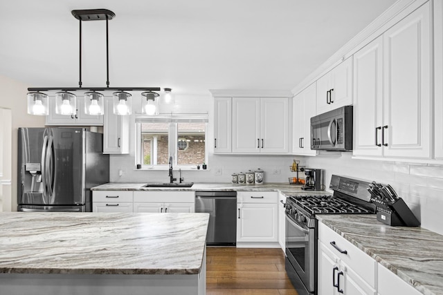 kitchen featuring white cabinetry, appliances with stainless steel finishes, a sink, and tasteful backsplash