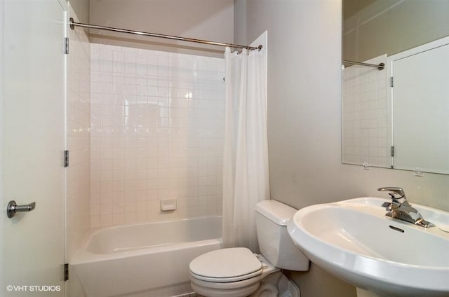 full bath featuring shower / bathtub combination with curtain, toilet, and a sink