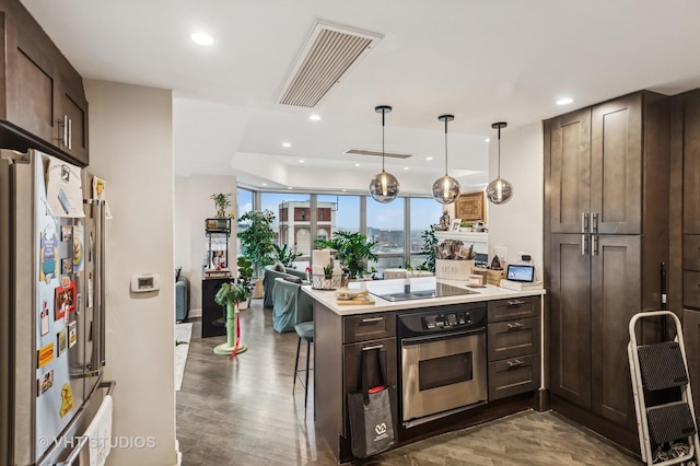 kitchen with a peninsula, stainless steel appliances, visible vents, and recessed lighting