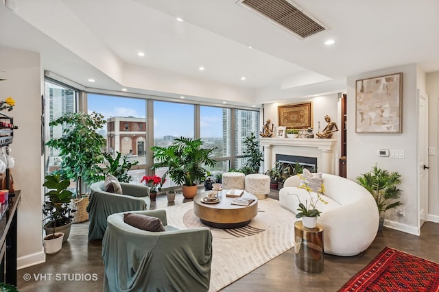 living area with baseboards, recessed lighting, a glass covered fireplace, and visible vents