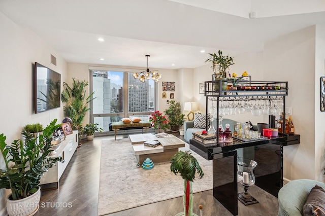 living area featuring a notable chandelier, recessed lighting, bar area, visible vents, and dark wood-type flooring