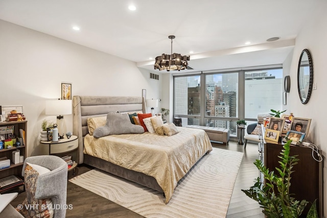 bedroom featuring an inviting chandelier, visible vents, wood finished floors, and recessed lighting