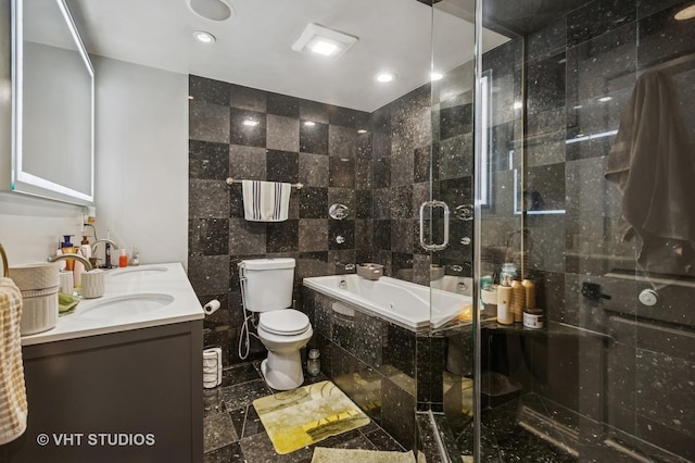 full bathroom featuring tile walls, toilet, tiled tub, double vanity, and a tile shower