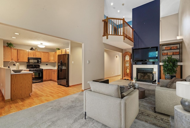 4232 Caribou Ct, Joliet, IL 60431 - living room with a towering ceiling, light wood-style flooring, a tile fireplace, and recessed lighting