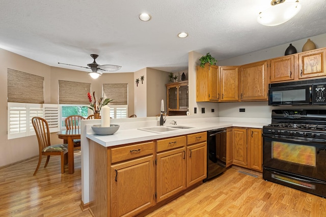 4232 Caribou Ct, Joliet, IL 60431 - kitchen featuring black appliances, light countertops, light wood-style flooring, a peninsula, and a textured ceiling