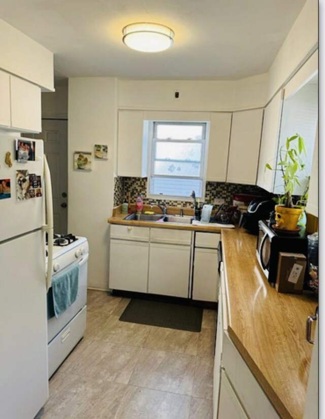 kitchen with white cabinets, white appliances, backsplash, and a sink