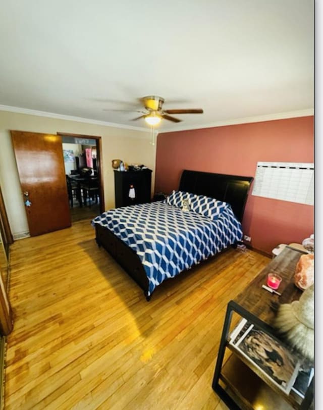 bedroom with crown molding, ceiling fan, and wood finished floors
