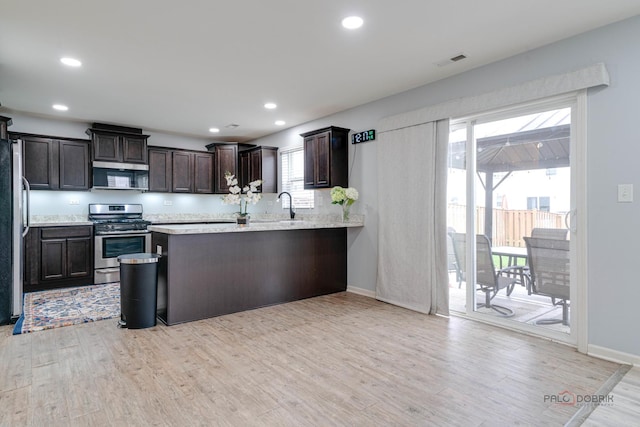 267 Maryland Ln, Pingree Grove, IL 60140 - kitchen with light wood finished floors, stainless steel appliances, dark brown cabinets, visible vents, and a sink