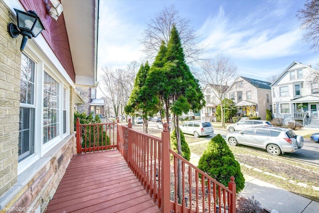 wooden deck featuring a porch and a residential view