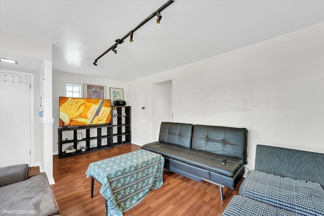 living room with baseboards, track lighting, and wood finished floors