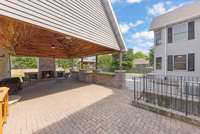2398 S Williamsburg Dr, Plainfield, IL 60586 - fenced backyard featuring an outdoor stone fireplace, a gazebo, a patio area, and ceiling fan
