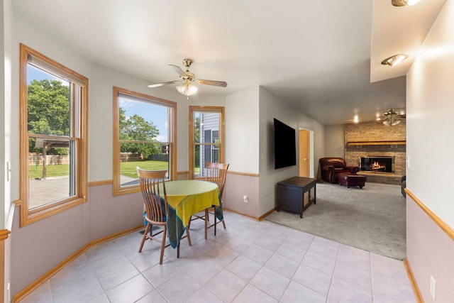 2398 S Williamsburg Dr, Plainfield, IL 60586 - dining area with light carpet, ceiling fan, a brick fireplace, and light tile patterned flooring