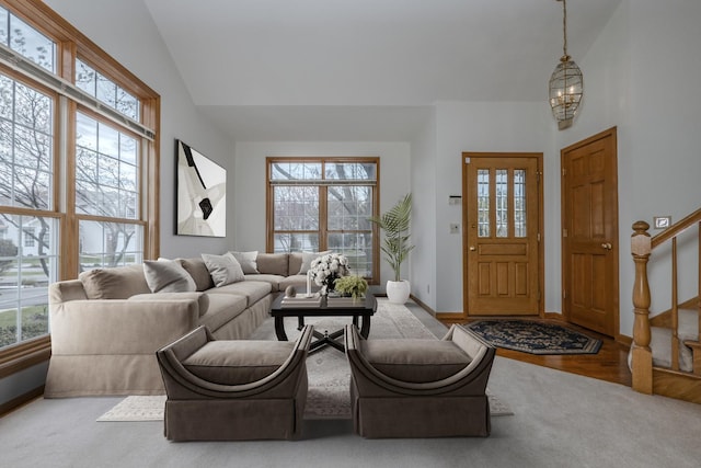 living area with high vaulted ceiling, stairway, wood finished floors, and baseboards