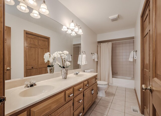 full bathroom featuring shower / tub combo with curtain, toilet, tile patterned flooring, and a sink