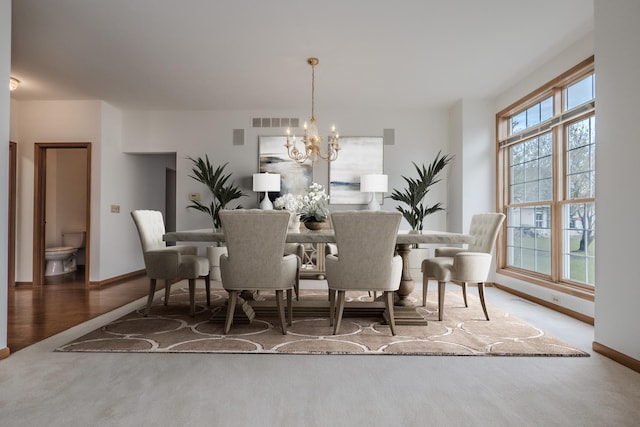 dining room with a notable chandelier, visible vents, and baseboards