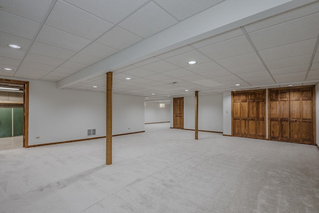 finished below grade area featuring visible vents, baseboards, recessed lighting, light carpet, and a paneled ceiling