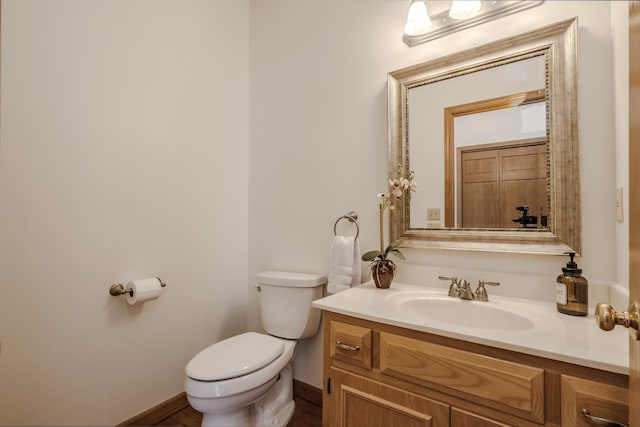 bathroom featuring vanity, toilet, and baseboards