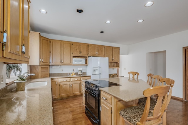 kitchen with a center island, white appliances, recessed lighting, and a sink