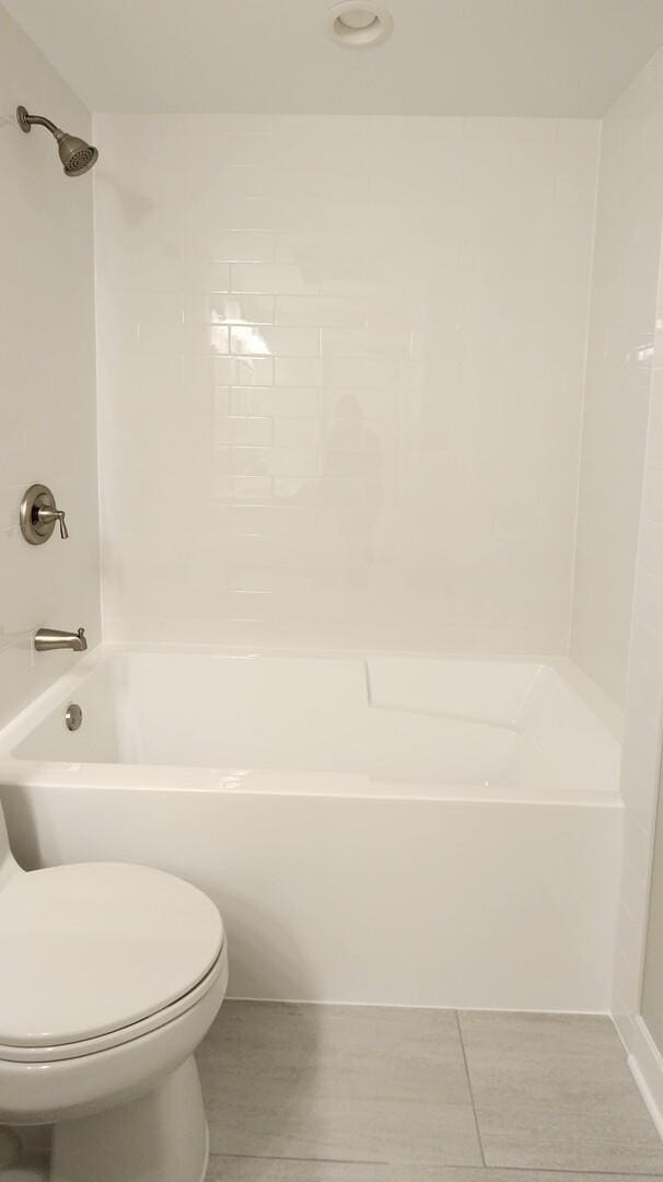 bathroom featuring toilet, tile patterned flooring, and shower / bath combination