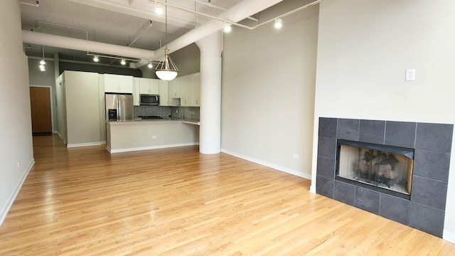 unfurnished living room featuring light wood-style floors and rail lighting