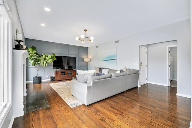 living room with a chandelier, baseboards, dark wood-type flooring, visible vents, and recessed lighting
