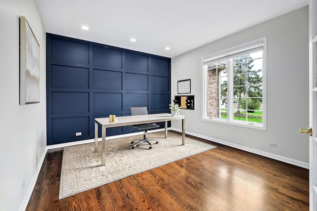 office space featuring recessed lighting, dark wood finished floors, a decorative wall, and baseboards