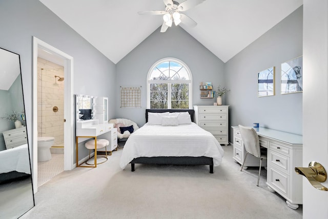 bedroom featuring vaulted ceiling, connected bathroom, light colored carpet, and a ceiling fan