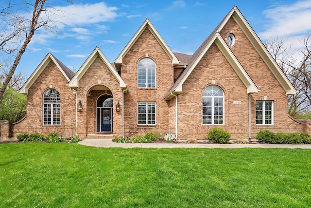 view of front of home featuring brick siding and a front yard