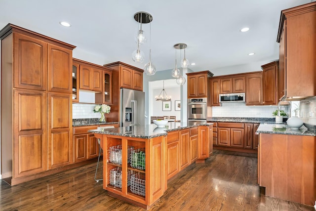 kitchen featuring dark wood finished floors, backsplash, a kitchen island, glass insert cabinets, and appliances with stainless steel finishes