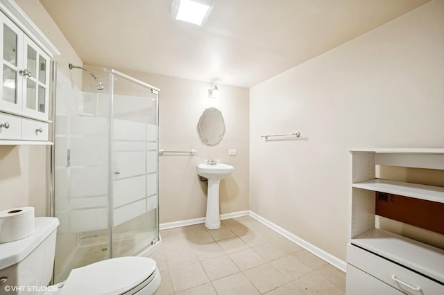 bathroom featuring tile patterned floors, baseboards, a shower stall, and toilet