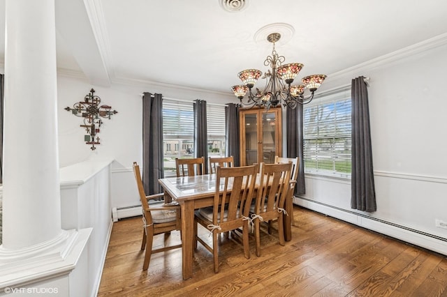 dining room with crown molding, light wood-style flooring, a baseboard heating unit, and a notable chandelier