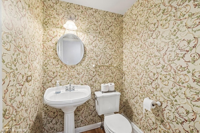 bathroom with toilet and wallpapered walls