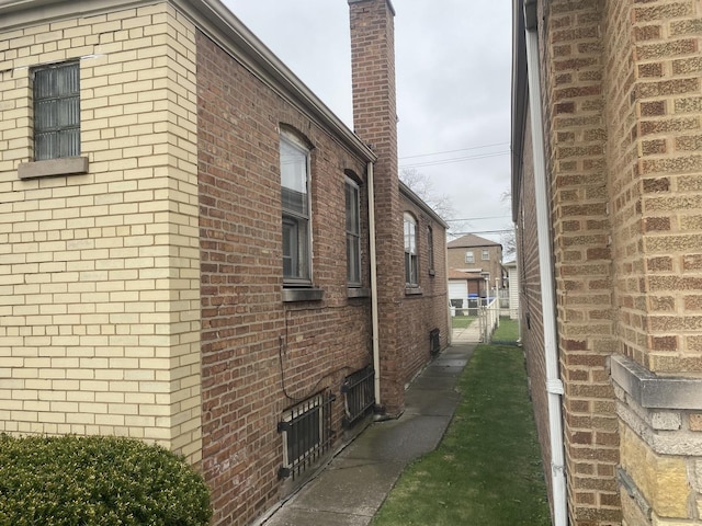 view of home's exterior with brick siding and fence