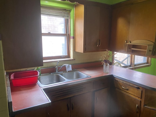 kitchen featuring brown cabinetry and a sink