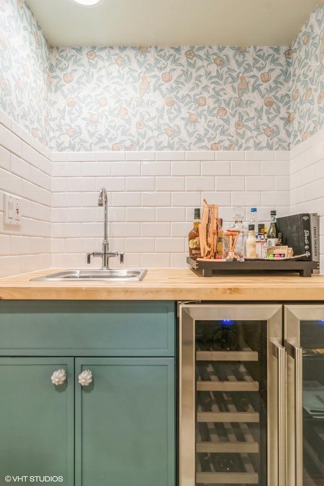 bar with bar, a sink, beverage cooler, wallpapered walls, and backsplash