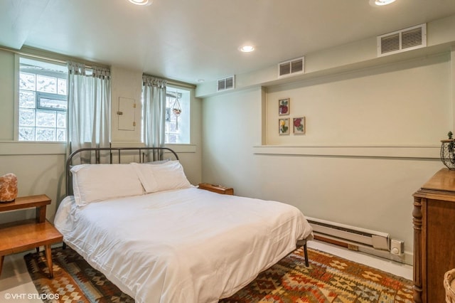 bedroom featuring visible vents, multiple windows, and a baseboard radiator
