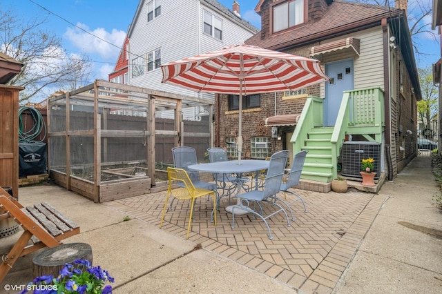 view of patio / terrace with central air condition unit, fence, and outdoor dining space