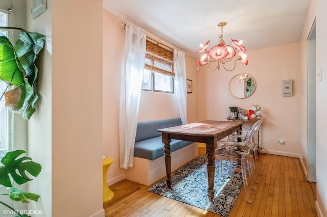 dining room with baseboards, hardwood / wood-style floors, and a notable chandelier