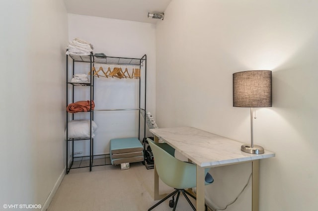 home office with baseboards and light carpet