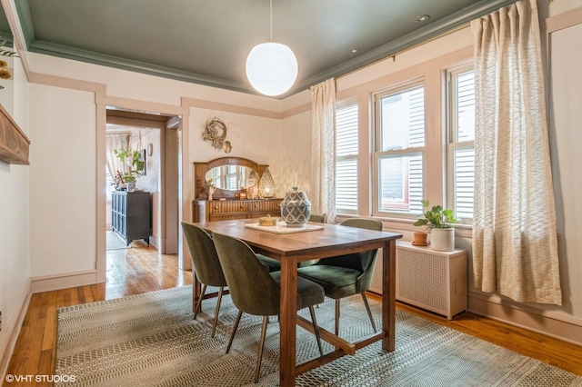 dining room featuring crown molding, baseboards, and light wood-style flooring