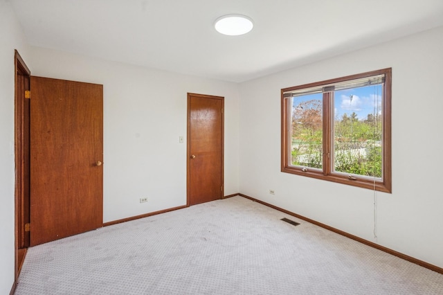 unfurnished bedroom featuring visible vents, baseboards, and light colored carpet