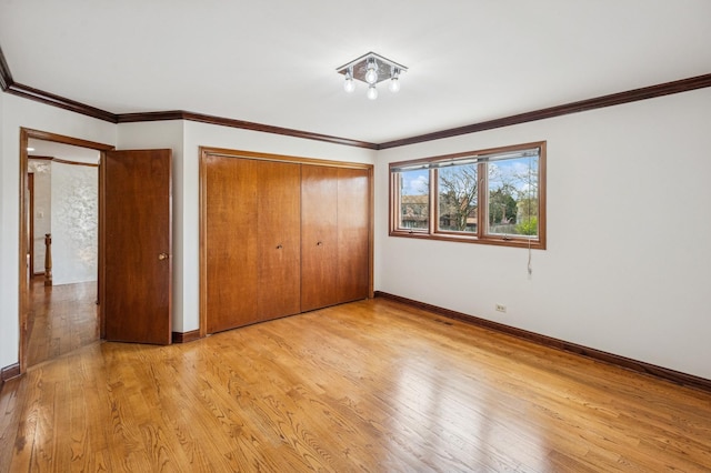 unfurnished bedroom featuring baseboards, a closet, and light wood finished floors
